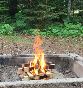 a bright campfire with sticks positioned at right angles from each other