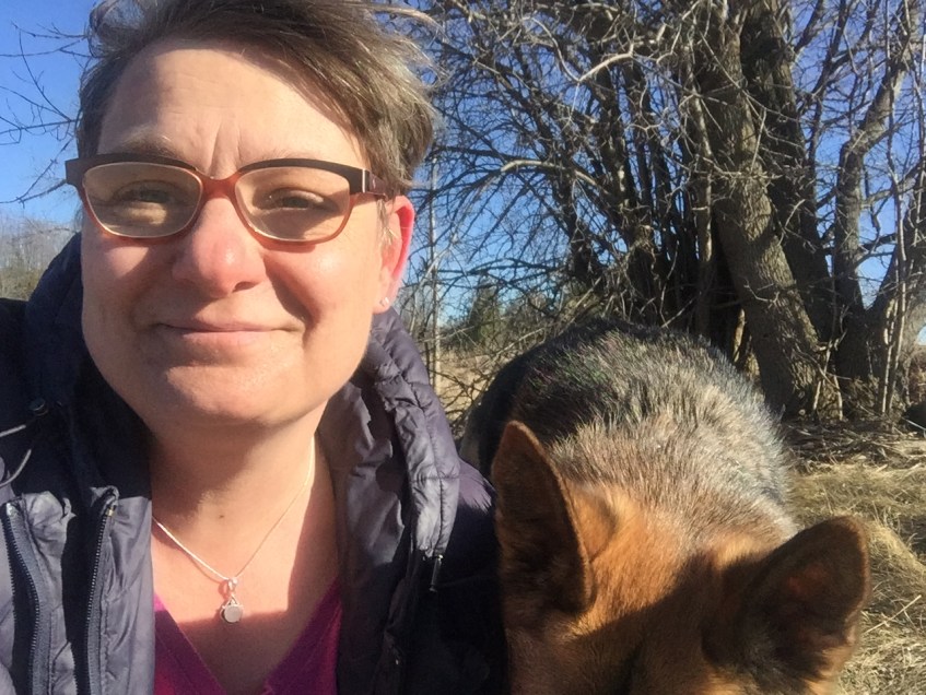 short haired woman's face and the top of a german shepherd dog's head